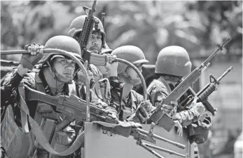  ?? NOEL CELIS, AFP/GETTY IMAGES ?? Soldiers drive through Philippine city Marawi, where militants began a drawn-out struggle.