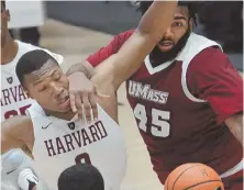  ?? STAFF PHOTO BY CHRIS CHRISTO ?? MAN IN THE MIDDLE: Harvard’s Chris Lewis (left) has become a strong inside presence for the Crimson.