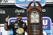  ?? STEVE HELBER — THE ASSOCIATED PRESS ?? Martin Truex Jr. (19) celebrates with the winners’ trophy after winning the NASCAR Cup Series auto race at Martinsvil­le Speedway in Martinsvil­le, Va., Sunday.