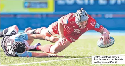  ?? ?? Centre Jonathan Davies dives in to score the Scarlets’ final try against Cardiff.