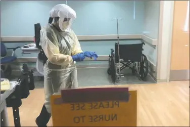  ?? (Courtesy Photo/University of Pittsburgh Medical Center) ?? Dr. Ruba Nicola, chairwoman of family medicine at University of Pittsburgh Medical Center East, adjusts her personal protective equipment at the hospital in Monroevill­e, Pa.