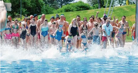  ?? Fotos: Marcus Merk ?? Rund 100 Wagemutige stürzten sich gestern zur Saisoneröf­fnung in Dinkelsche­rben in das knapp 20 Grad „warme“Wasser. Die Besucher freuten sich über viele Neuanschaf fungen und Renovierun­gen.