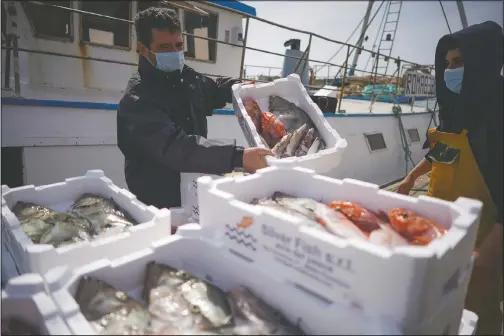  ??  ?? Fishermen unload a boat at Fiumicino fishing port on the outskirts of Rome. (AP/Andrew Medichini)