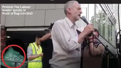  ??  ?? Protest: The Labour leader speaks in front of flag (circled)