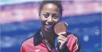  ??  ?? Jennifer Abel montre fièrement la médaille de bronze qu’elle a obtenue en plongeon, au tremplin de trois mètres. - La Presse canadienne