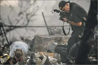  ?? Marcus Yam Los Angeles Times ?? A SEARCH team documents suspected human remains at a destroyed building Friday in Paradise.