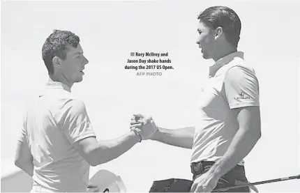  ?? AFP PHOTO ?? Rory McIlroy and Jason Day shake hands during the 2017 US Open.