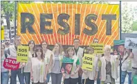  ?? AP PHOTO ?? Greenpeace protesters stand in silence with banners outside the U.S. embassy in Madrid, Spain, Friday. The protesters gathered at the gates of the United States embassy in the Spanish capital to protest President Donald Trump’s decision to pull the...