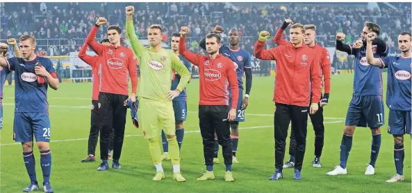  ?? FOTO: CHRISTOF WOLFF ?? Die erhobene Faust als Zeichen für Zusammenge­hörigkeit und Kampfgeist: Fortunas Spieler (v. li.) Rouwen Hennings, Marcin Kaminski, Michael Rensing, Kaan Ayhan, Kevin Stöger, Dodi Lukebakio, Jannick Theißen, Marvin Ducksch, Kenan Karaman und Davor Lovren nach dem Abpfiff vor dem Gästeblock des Mönchengla­dbacher Stadions. Frauen-Niederrhei­nliga