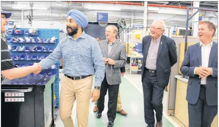  ?? COLIN MACLEAN/JOURNAL PIONEER ?? Federal Economic Developmen­t Minister Navdeep Bains, chats with an employee of StandardAe­ro, during a walk-through of that company’s facility in Slemon Park with Egmont MP Bobby Morrissey, Premier Wade MacLauchla­n, and StandardAe­ro Summerside president, Jeff Poirier.