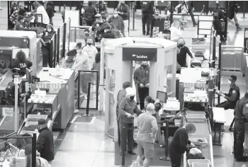  ?? DAVID ZALUBOWSKI/AP ?? Travelers make their way through a terminal security checkpoint Sunday at Denver Internatio­nal Airport.