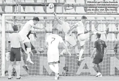  ?? - Gambar REUTERS/Antonio Bronic ?? PENJAGA gol Croatia Dominik Livakovic, menolak bola keluar dari kawasan kubunya walaupun cuba dicabar oleh John Stones.