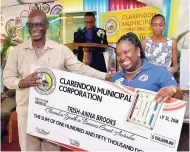  ??  ?? Local Government and Community Developmen­t Minister Desmond McKenzie (left) presents a symbolic grant cheque in the sum of $150,000 to a participan­t in the Clarendon Municipal Corporatio­n’s (CMC) Clarendon Youth In Business training programme,...