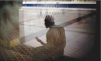  ??  ?? A man is reflected in a window as he prays outside the main prayer hall at the National Mosque of Malaysia in Kuala Lumpur (file). Malaysia’s finance ministry has approved a plan to revive the balance sheet of Lembaga Tabung Haji, a state fund tasked with helping Muslims save for a pilgrimage to Makkah.