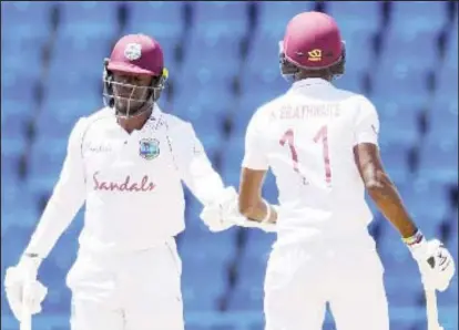  ??  ?? Nkrumah Bonner (left) and captain Kraigg Brathwaite confer during their half-century stand on the final day of the opening Test.