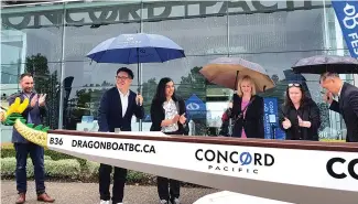  ?? ?? Concord Pacific president and CEO Terry Hui (with blue umbrella) and, to his left, MLA Niki Sharma and Coun. Sarah Kirby-Yung, were among those who unveiled 18 new dragon boats on June 9.