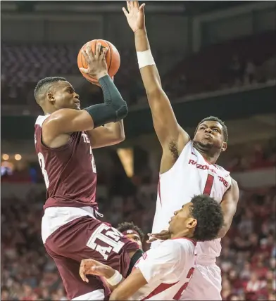  ?? Alan Jamison/Special to the News-Times ?? Good defense: Arkansas Razorbacks forward Trey Thompson (1) swats at the shot of Texas A&amp;M Aggies guard Danuel House (23) while former Razorbacks guard Jimmy Whitt (24) takes a charge during their SEC clash last season in Fayettevil­le. The Razorbacks are currently preparing for a four-game exhibition in Spain.