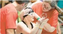  ?? ?? Swimming athlete Emily Moses gets help from coaches Jeff Glazier, left, and Kimberly Overcast, as Moses prepares to compete during the Special Olympics Florida 2023 State Aquatics Invitation­al at the Rosen Aquatic Center.