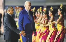  ?? AP ?? Joe Biden walks past Balinese dancers after disembarki­ng Air Force One upon his arrival in Bali, Indonesia, yesterday.