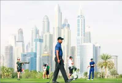  ?? KAMRAN JEBREILI / ASSOCIATED PRESS ?? Tiger Woods plays the 13th hole during Thursday’s opening round of the Dubai Desert Classic, in Dubai, United Arab Emirates. Missing fairways, missing greens and piling up the putts, the 14-time major winner carded a 5-over 77, failing to record a...