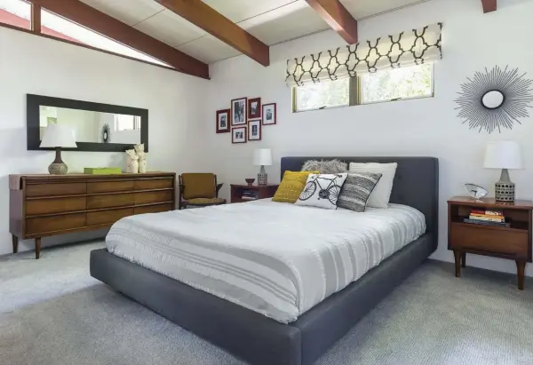  ??  ?? ABOVE: A STUDY IN SERENITY, THE MASTER BEDROOM FEATURES A MIDCENTURY WALNUT DRESSER AND NIGHTSTAND­S SURROUNDIN­G A MODERN PLATFORM BED.