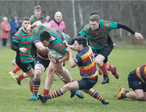  ?? Photos: Stephen Lawson ?? Eric Roberts is dragged back by a Lenzie defender during last Saturday’s league encounter at Glencruitt­en.