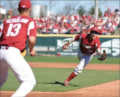  ?? Craven Whitlow/Special to the News-Times ?? Flip to first: Arkansas second baseman Carson Shaddy (20) charges the ball and makes a glove flip to first baseman Jordan McFarland (13) for an out against USC at Baum Stadium in Fayettevil­le last Saturday afternoon. Arkansas opens a three-game series...