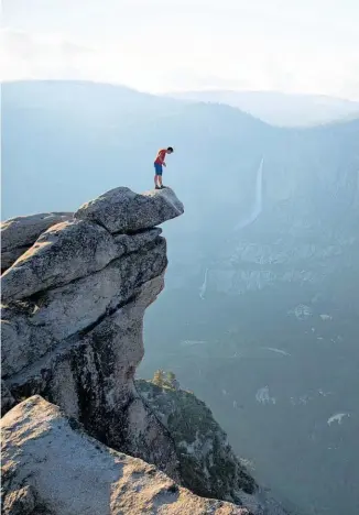  ?? Photos / National Geographic/Jimmy Chin ?? Alex Honnold peers over the edge of Glacier Point in Yosemite National Park, above. He had just climbed 600m from the valley floor.