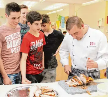  ?? Foto: Andreas Hoehne ?? Auch das Schneiden des Bratens machte Martin Brink den Achtklässl­ern (von links) Thomas Nuscheler, Jannis Jannotta, Franz Schmid und Elias Socher vor.