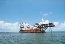  ?? Janet McConnaugh­ey / Associated Press ?? A dredge pumps sand and water last week from the Gulf of Mexico to help rebuild West Grand Terre Island, La.