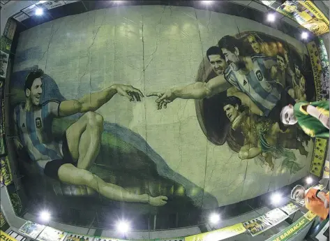  ?? JUAN MABROMATA/AFP ?? Buenos Aires artist Santiago Barbeito has painted the ceiling of the arena at the Sportivo Pereyra de Barracas club to depict a version of Michelange­lo's famous ‘Creation of Adam’. The mural, which represents the enduring tradition of Argentine soccer,...