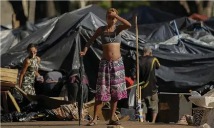  ?? Photograph: André Penner/AP ?? A young woman watches an operation to remove tents used by homeless people in downtown Sao Paulo, Brazil on 4 April 2022.