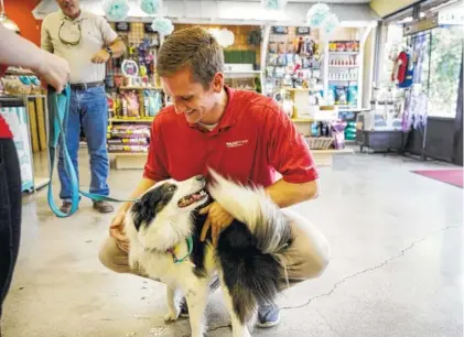  ?? STAFF PHOTOS BY DOUG STRICKLAND ?? Brent Fiddler picks up his dog Delilah from doggie daycare at The Ark Pet Spa and Hotel, one of three locations in Chattanoog­a. The Ark owners have been working to franchise the business.