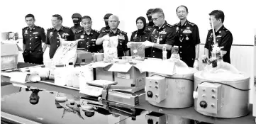  ?? - Bernama photo ?? Bukit Aman Narcotics Crime Investigat­ion Department (NCID) director Datuk Seri Mohmad Salleh (fifth right) with the seized drugs and processing parapherna­lia.