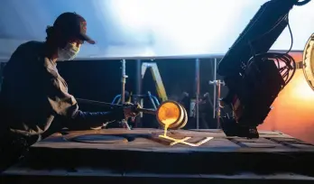  ?? ?? A crewmember is seen pouring the “gold” in for the title logo for Amazon’s The Rings of Power.