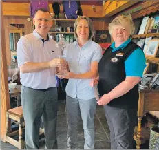  ??  ?? Machrihani­sh Dunes’ general manager, Andy Hogan, and golf house manager, Lorna Barr, present the ladies’ Campbeltow­n Open trophy to Anne Laing, centre.