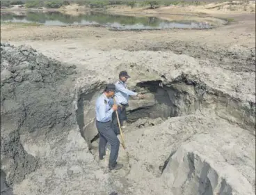  ?? SANCHIT KHANNA/HT PHOTO ?? Members of team Rakshak show a pit dug by the sand mafia in the Yamuna floodplain in New Usmanpur area of northeast Delhi.