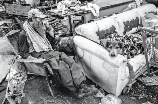  ?? Santiago Mejia / The Chronicle ?? TAKING A BREAK: A man named Tom relaxes with his dog, Winter, at a friend’s campsite near Fifth and Market streets in Oakland, across the street from where Tom makes his camp.