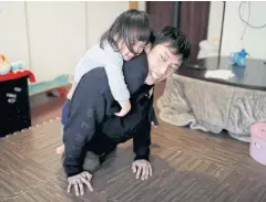  ??  ?? Kenta Kambara plays with his daughter Shiori, 2, at their home in Tokyo.