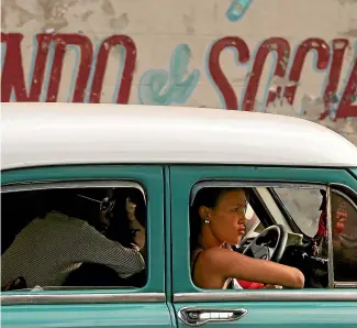  ?? GETTY IMAGES ?? With Cuba’s economy hurt by US economic sanctions, a common practice to save money is for Cuban commuters to share taxis. These commuters make the journey home along San Lazaro St in the Vedado district in 1950s-era cars common on Cuba’s streets. Fidel Castro banned imports on both foreign cars and car parts when he took power in 1959.