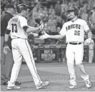  ?? AP ?? The Diamondbac­ks’ Nick Ahmed (13) and Shelby Miller celebrate after scoring on a Paul Goldschmid­t hit during the fifth inning of Friday night’s game at Chase Field.