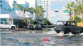  ?? COURTESY PHOTOS ?? Sen. Bill Nelson showed his colleagues three photos of sea-level rise, including this image from Miami Beach, where king tides had flooded the street on a sunny day.