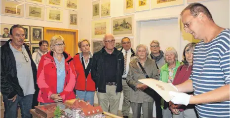  ?? FOTOS: SABINE FELKER ?? Volker Neipp (rechts) mit einer historisch­en Urkunde. Damit die keinen Schaden nimmt, trägt er säurefreie Handschuhe.