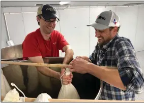  ?? (Special to the Democrat-Gazette) ?? Vice president Ben Bell and Cassady Harris, director of operations, gravity press the first batches of sake at Origami Sake Brewery in Hot Springs.