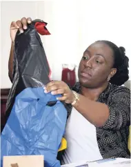  ?? RICARDO MAKYN/MULTIMEDIA PHOTO EDITOR ?? Ollyvia Anderson, public relations officer at NEPA, shows bags that will be prohibited once the January 1 ban on certain single-use plastic products takes effect.