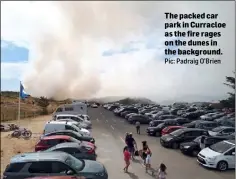  ?? Pic: Padraig O’Brien ?? The packed car park in Curracloe as the fire rages on the dunes in the background.