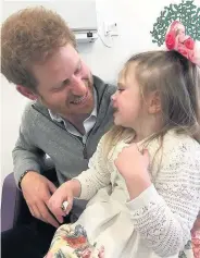  ??  ?? Prince Harry cradles Ollie Carroll during his surprise meeting in hospital and having fun with sister Amelia, who also has Battens Disease