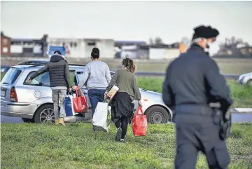  ??  ?? AISALDOS. UN GRUPO DE PERSONAS, QUE TRANSPORTA­N ALGUNOS BIENES, ESPERAN PARA PODER INGRESAR A CASALPUSTE­RLENGO, DESPUÉS DE QUE EL NUEVO DECRETO DEL GOBIERNO ITALIANO EXTENDIÓ LA CUARENTENA A TODA LA REGIÓN DE LOMBARDÍA