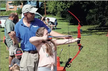  ?? / Doug Walker ?? Rome-Floyd ECO Center biologist Jason Hosford helps Kai’lee Murray, 9 sight in her shot during the program for home-schooled students at the ECO Center Tuesday. first ever archery