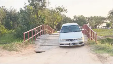  ?? ?? A vehicle crosses the bridge with the hole evident